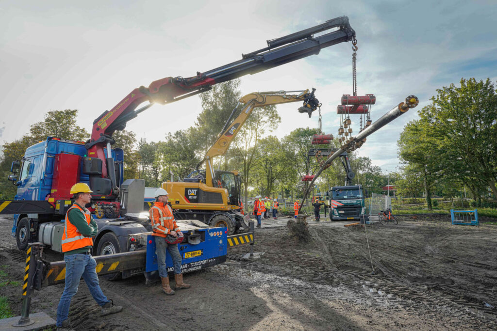 Foto monteurs en machines plaatsen warmteleiding tijdens aanleg warmtenet in Zaanstad.